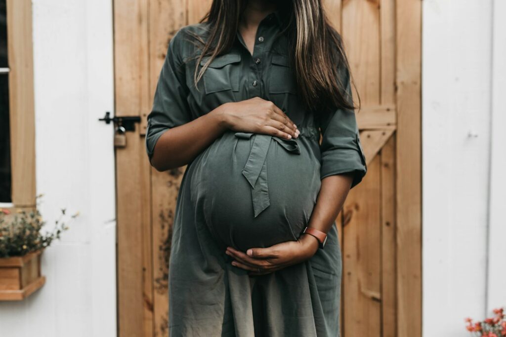 Pregnant woman holding her bump, illustrating an apron belly pregnancy guide