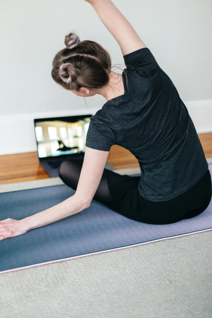 Woman lying on a yoga mat doing gentle core work to support an apron belly and diastasis recti