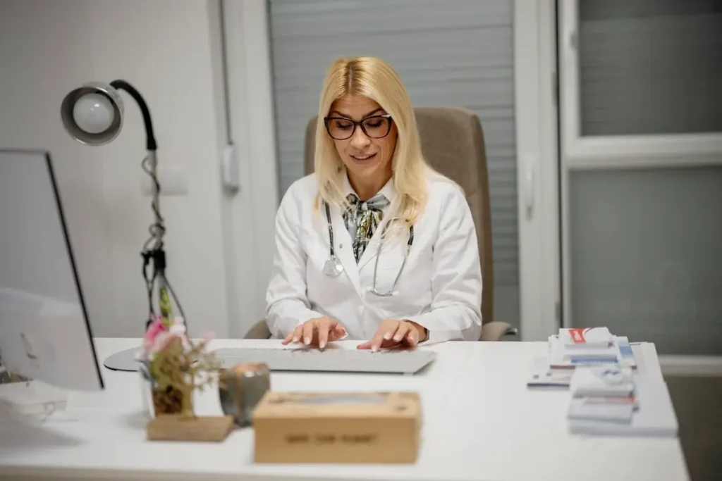 Female GP at her desk preparing for a patient appointment after hysterectomy