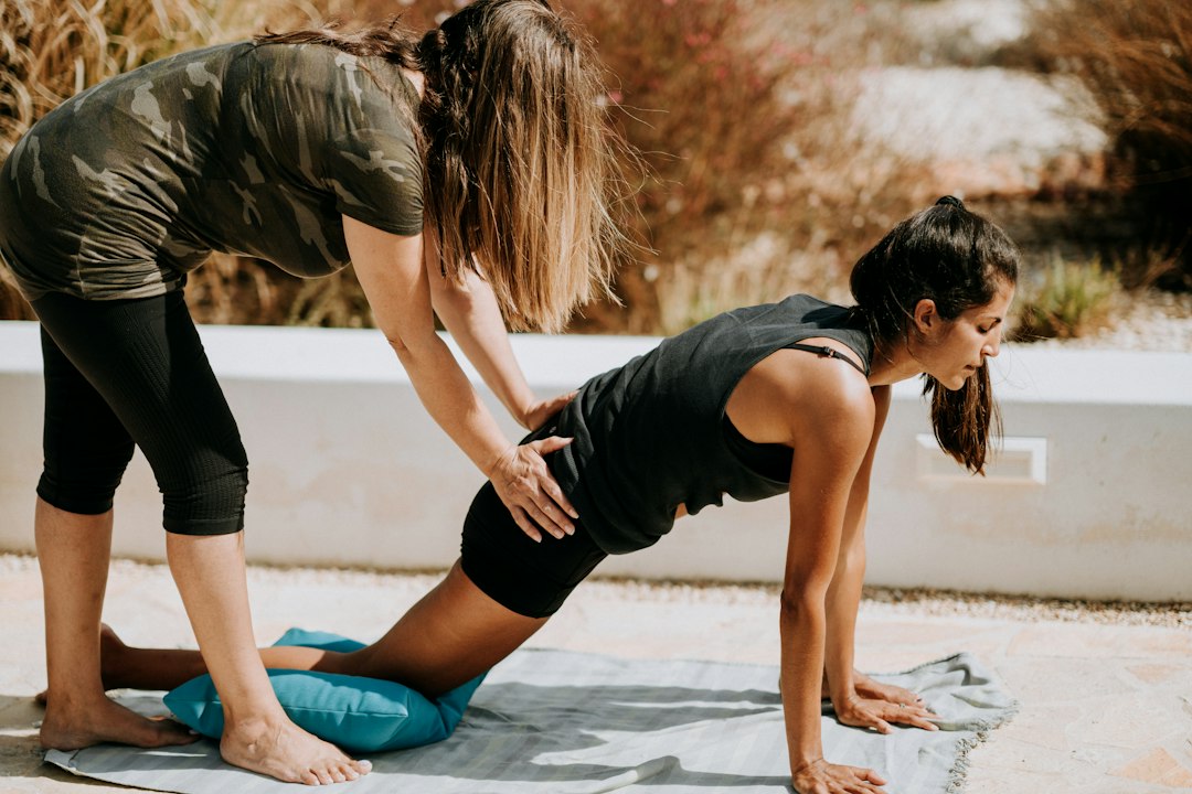 Woman kneeling on an exercise mat doing a hip flexor stretch to improve posture and a lower belly fold